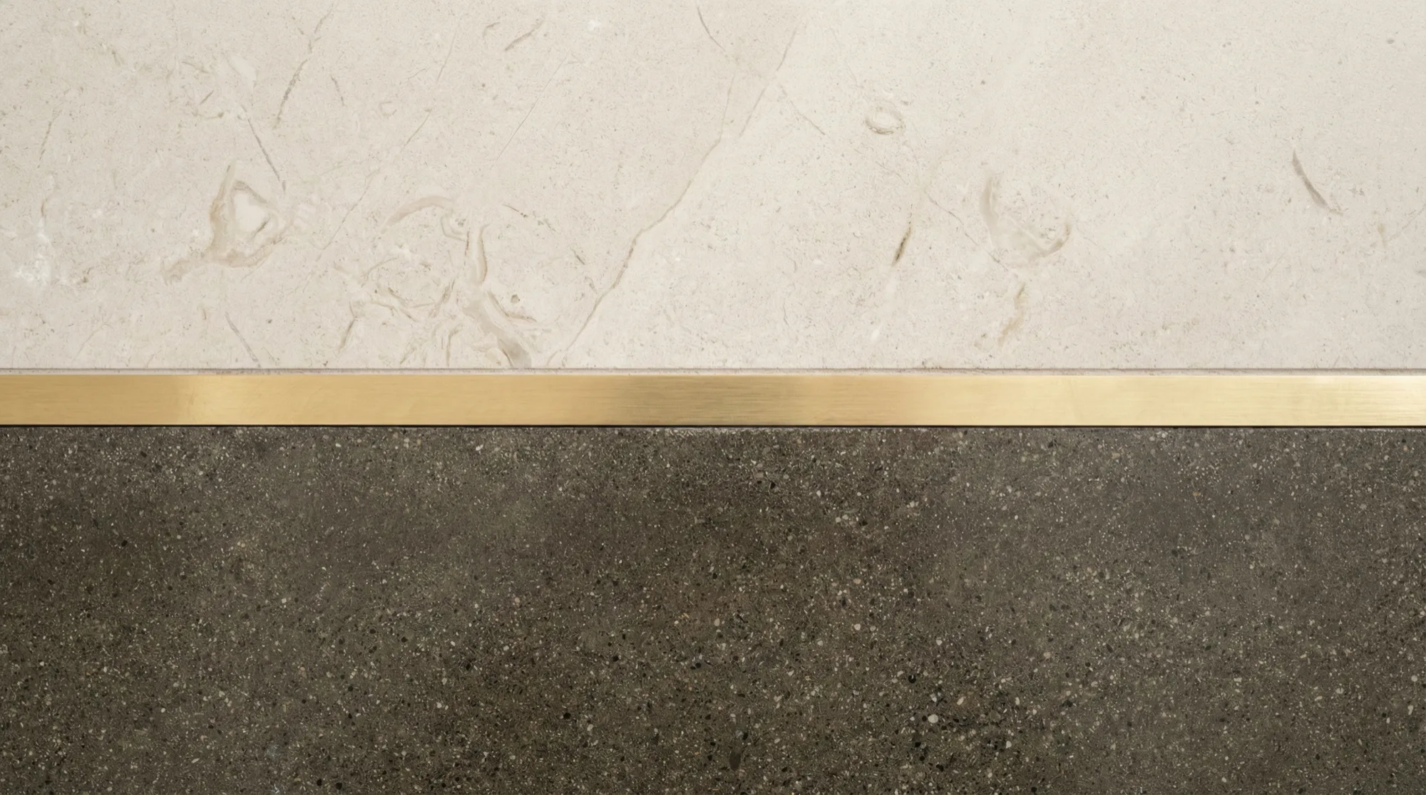 A brass inlay meeting stone and timber in one resolved junction
